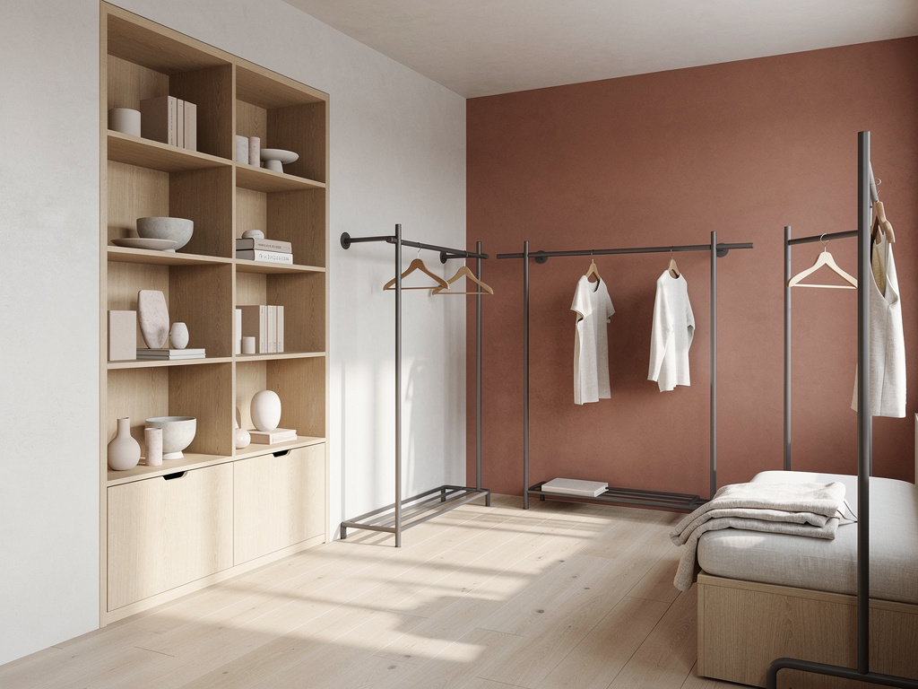 A compact boutique interior with oak shelving, graphite metal fixtures and a terracotta accent wall in soft daylight.